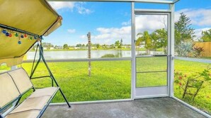 A conservatory with a bench, a view of a grassy area, and a clear sky. - Sunseeker Paradise for 8! (Port Charlotte)