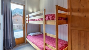 Dormitorio con literas y vistas a la montaña y un edificio.