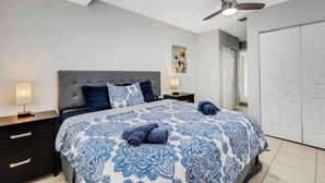A bedroom with a bed, nightstands, a ceiling fan, and a wardrobe. - Tropical Paradise for 8 (Bradenton)