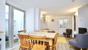 Un coin repas avec une table et des chaises en bois, un canapé et un téléviseur.