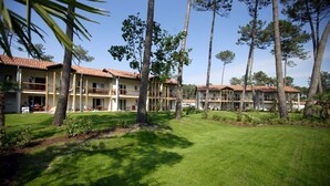 A hotel with multiple floors, outdoor seating areas, and a well-maintained lawn. - Apartment in Landes for 6/7 persons, pet friendly (Ondres)