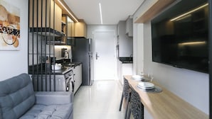 Eine moderne Küche mit Einbauofen, Kühlschrank und Essbereich mit Tisch und Stühlen.