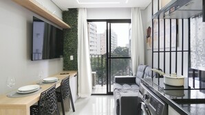Eine moderne Küche mit Essbereich, einem an der Wand befestigten Fernseher und einem Balkon mit Blick auf die Stadt.