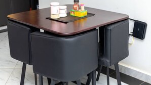 A small dining area with a dark wooden table and two black chairs.