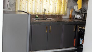 A kitchen with a refrigerator, sink, and oven.