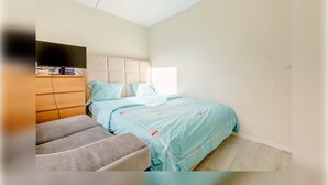 A bedroom with a bed, a sofa, a TV, and a wooden cabinet. - Private Room in Lille Centre (Lille)