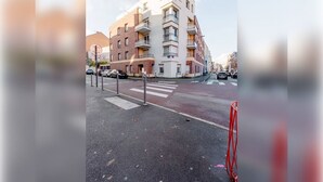 A multi-story building with balconies, a pedestrian crossing, and parked cars. - Private Room in Lille Centre (Lille)
