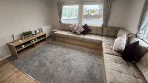 A cozy living room with a sofa, a wooden side table, and a grey rug.