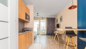 Una cocina moderna con armarios de madera, microondas integrado y un comedor con mesa y sillas.