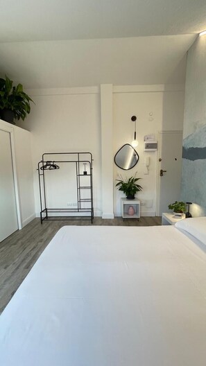 A hotel room with a bunk bed, a bedside table with a lamp, a potted plant, and a painting on the wall. - Cosy studios in Rapallo (Rapallo)
