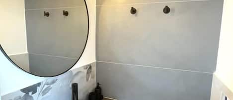 Ein modernes Badezimmer mit Toilette, Waschbecken und Spiegel.