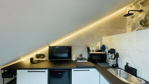 Een moderne keuken met een ingebouwde magnetron, een spoelbak en een televisie.