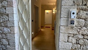 Une façade en pierre avec une porte donnant sur un couloir.