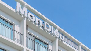 Un edificio de hotel con un cartel llamativo que dice "Mon Dieu".