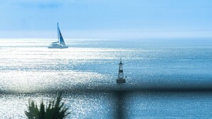 Un velero en un mar tranquilo con un faro al frente.