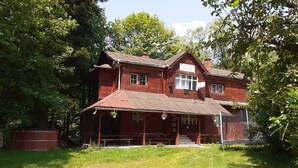 A two-story wooden building with a porch and a sign that reads "PEOPLE'S HOUSE". - Pensiunea Szurdok - Antonia Panzió (Baile Tusnad)