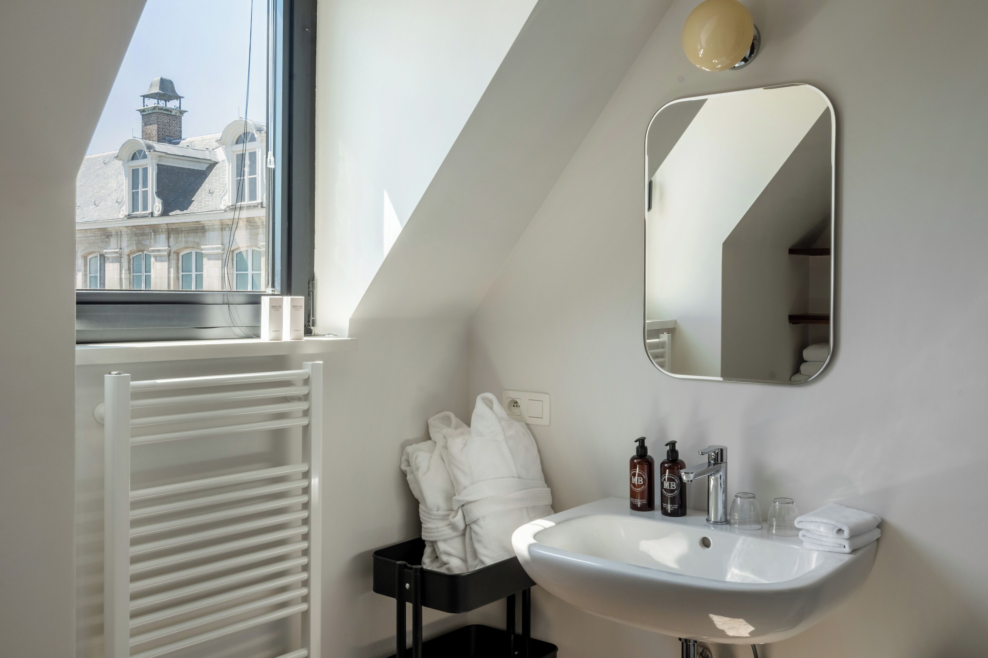 Ein modernes Badezimmer mit Waschbecken, Spiegel und Handtuchhalter.