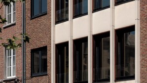 A multi-story building with a brick facade and large windows. - A place - Vrijdagmarkt 1 (Antwerp)