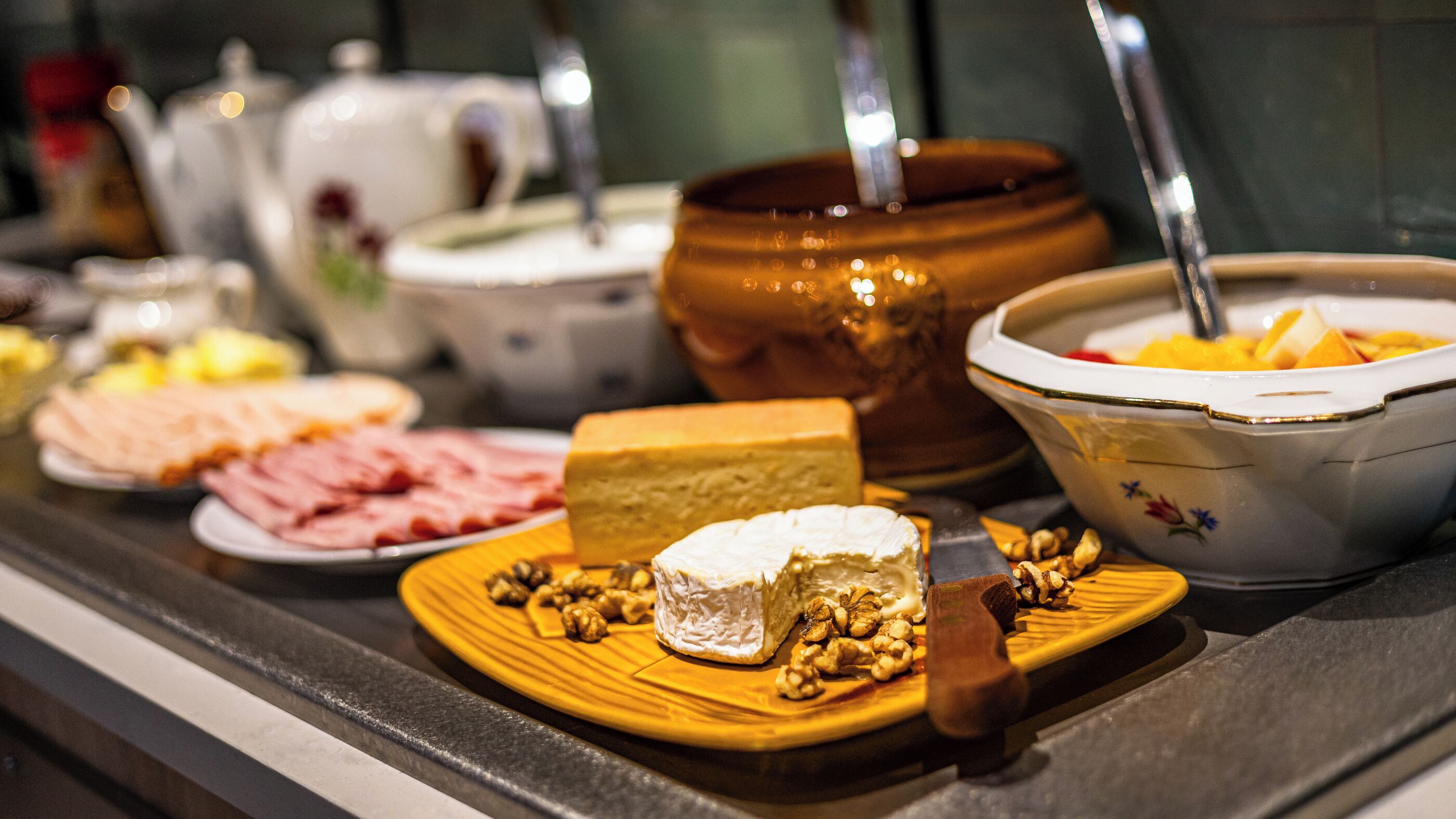 A buffet table with various food items including cheese, nuts, and fruits.