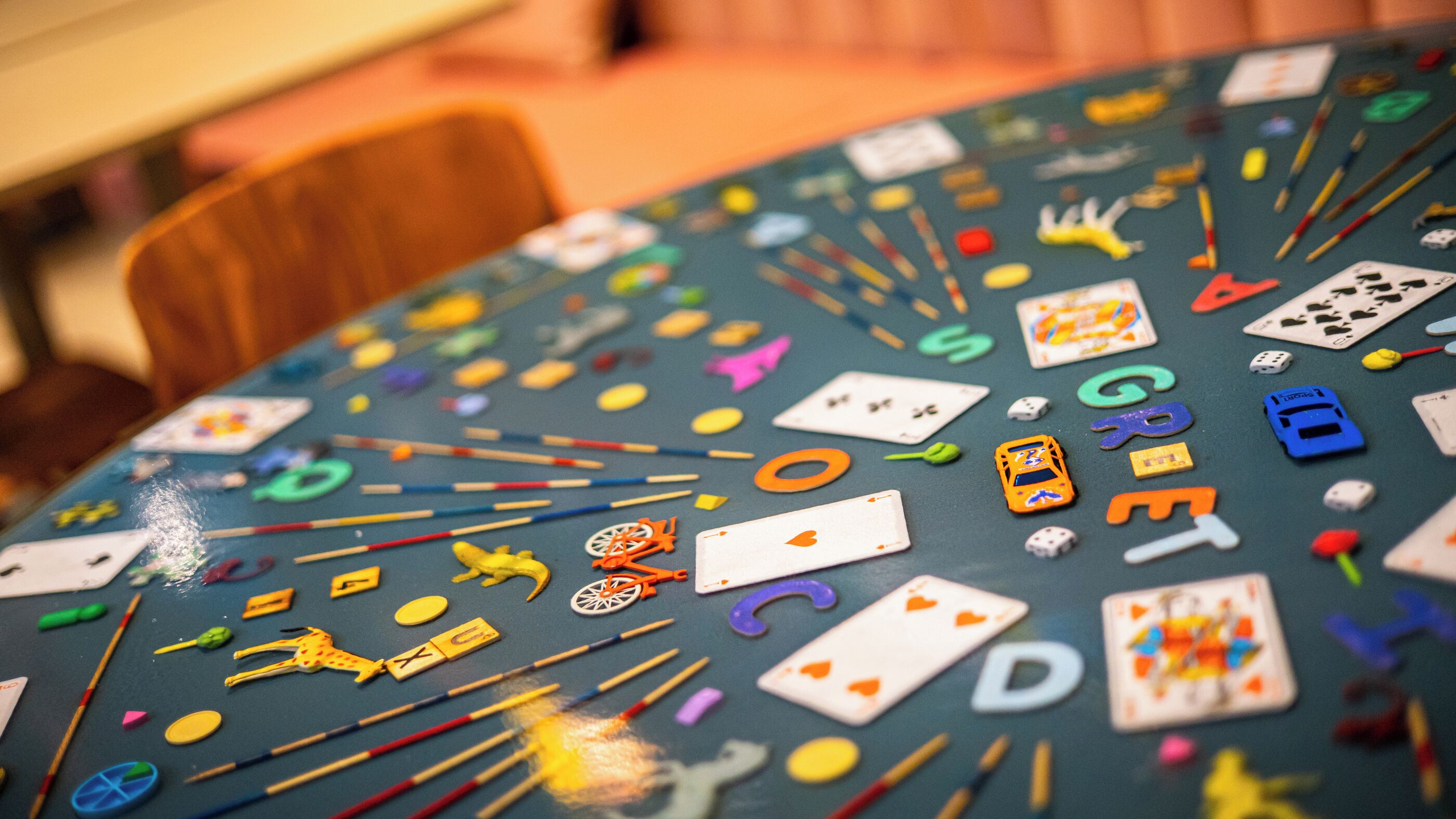 A round table covered with various playing cards and colorful objects.