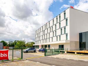 Un edificio moderno con tetto piatto, ampie finestre e un ingresso carrabile.