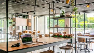 A modern office space with a long table, chairs, and a laptop.