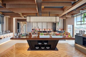 Una cocina moderna con una isla central, armarios de madera y varios alimentos exhibidos en la encimera.