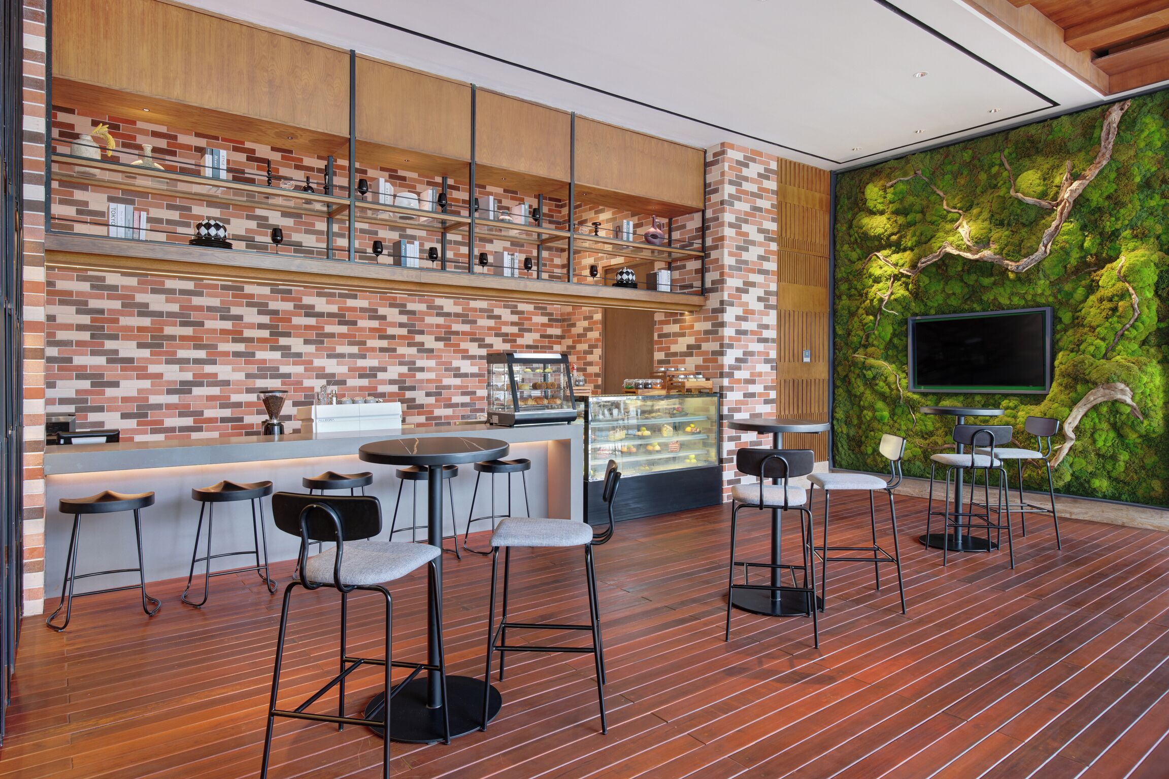Zona de bar moderna con pared de ladrillo, estantes de madera y pared cubierta de musgo.