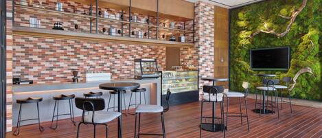 Zona de bar moderna con pared de ladrillo, estantes de madera y pared cubierta de musgo.
