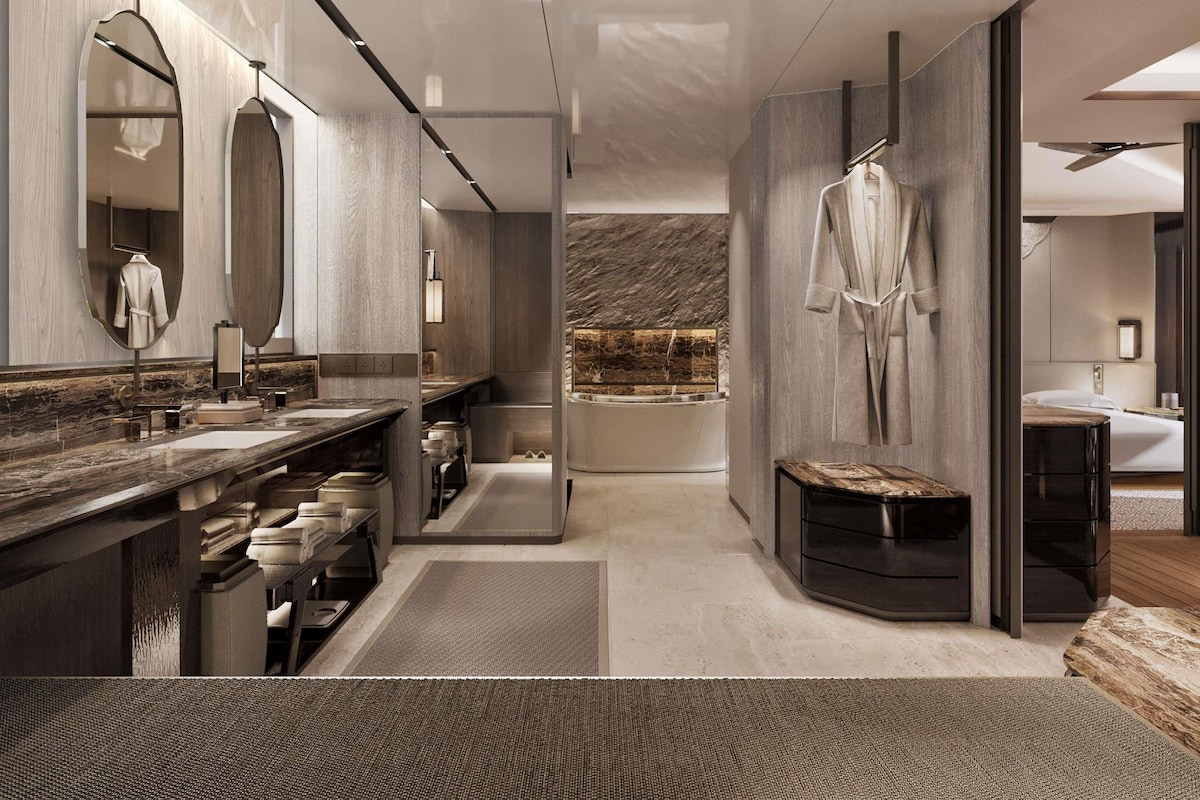 A modern bathroom with a large mirror, a bathtub, and a shower area.