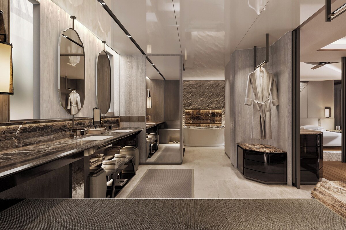 A modern bathroom with a large mirror, two sinks, a bench, and a bathtub.