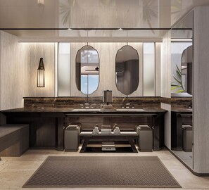 A modern bathroom with a large mirror, a wall-mounted light, and a marble countertop. - Navera Phuket - Mgallery Collection (Choeng Thale)