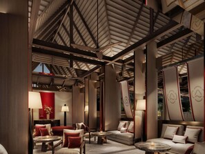 A modern interior with a high ceiling, wooden beams, and a seating area with sofas and tables. - Navera Phuket - Mgallery Collection (Choeng Thale)
