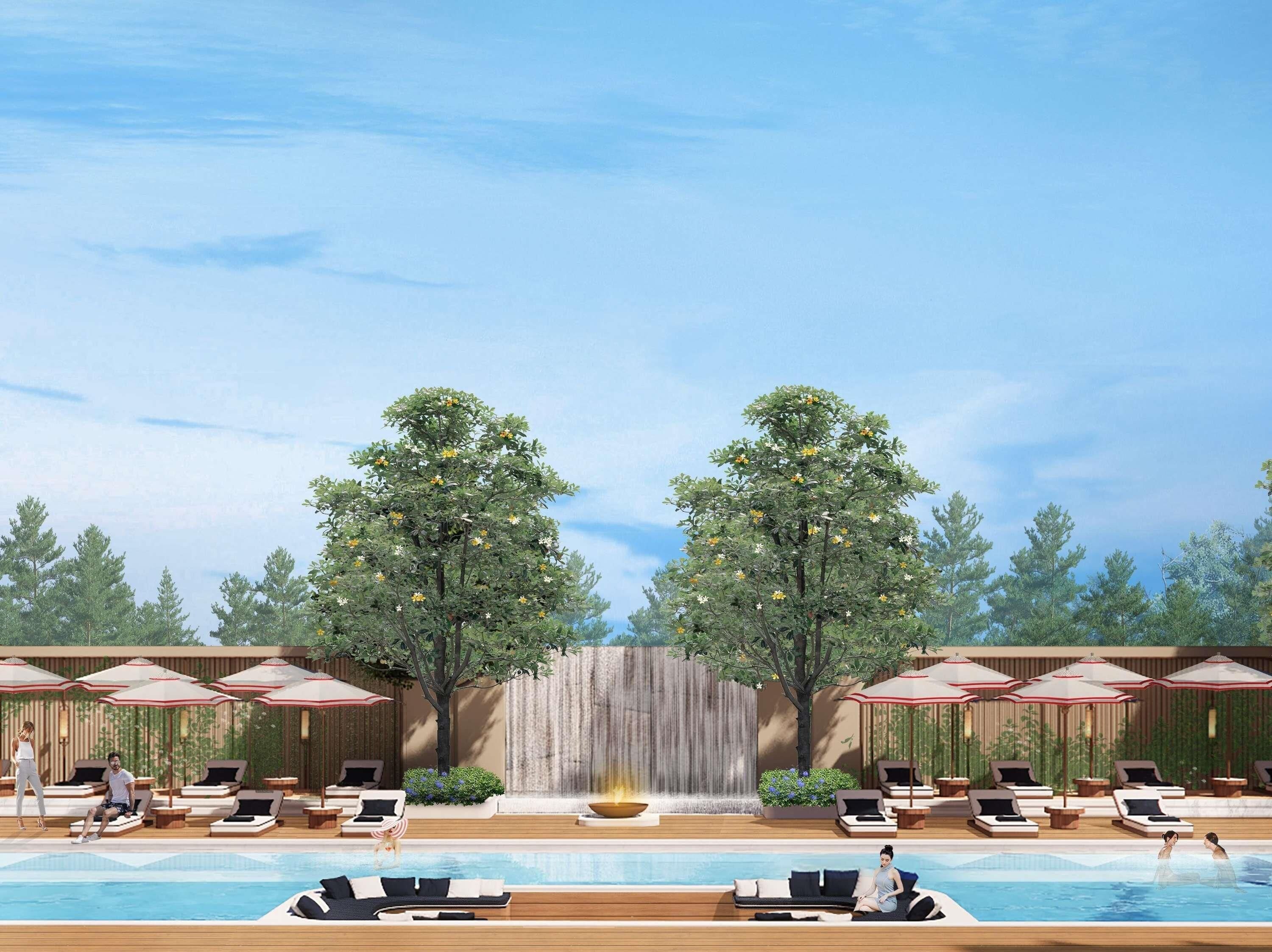 A poolside area with lounge chairs, umbrellas, and a waterfall.