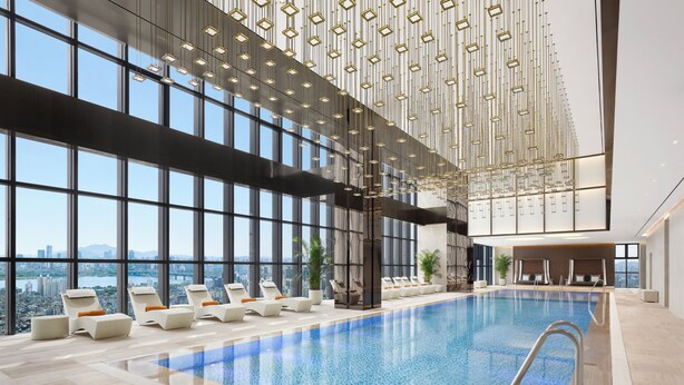 Una piscina interior moderna con vistas a la ciudad, amplias ventanas y luminarias contemporáneas.