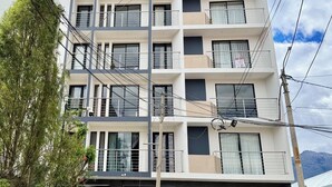 A multi-story building with balconies, a storefront, and a parked motorcycle. - 3 RB, Fast Wi-Fi, mountain view, barbecue area, garage. elevator. (Huaraz)