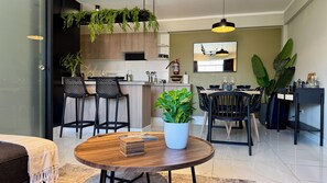 Una cocina moderna con armarios de madera, una barra con taburetes y una mesa de comedor para cuatro.