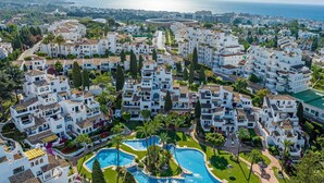 A coastal residential area with white buildings, a central swimming pool, and a view of the sea. - Luxurious 3BDR apartment Puerto Banús, Marbella (Marbella)