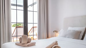 A hotel room with a large bed, a nightstand, a lamp, and a view through a window. - Luxurious 3BDR apartment Puerto Banús, Marbella (Marbella)