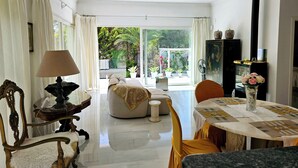 Una habitación amplia con un ventanal grande, una mesa de comedor, un sofá y un aparador decorativo.