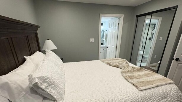Una camera da letto con un letto grande, una testiera in legno e uno specchio sulla parete.