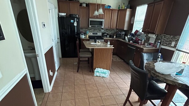 A kitchen with a central island, wooden cabinets, and a tiled floor. - This property is not available any longer sorry for inconvenience (Moncks Corner)