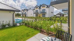 A residential area with modern houses, a swimming pool, and a well-maintained lawn. - Apartamenty Sun & Snow Bałtycka Oaza (Wladyslawowo)
