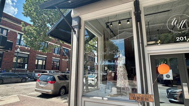 A storefront with a 'WELCOME OPEN' sign, a clear sky, and a brick building in the background. - The Texas Bluebonnet, Historic Downtown McKinney Area! (McKinney)