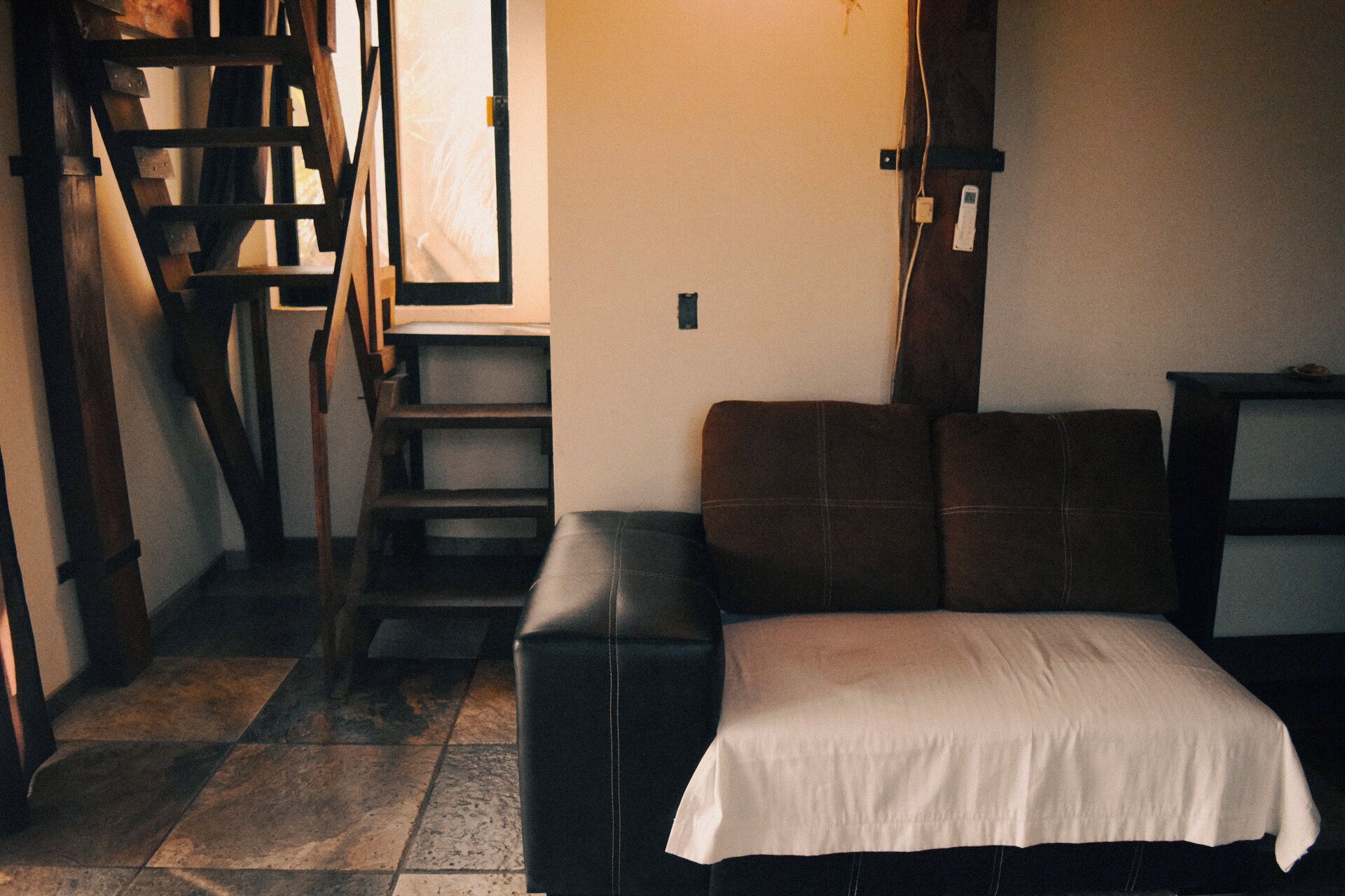 Una habitación con una cama, una escalera de madera y una escalera.