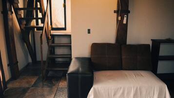 Una habitación con una cama, una escalera de madera y una escalera.