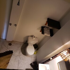 A bathroom with a toilet, a sink, and a mirror. - Beachfrontguesthouse (Puerto Escondido)
