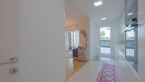 Eine moderne Küche mit weißen Schränken und einem großen Fenster.