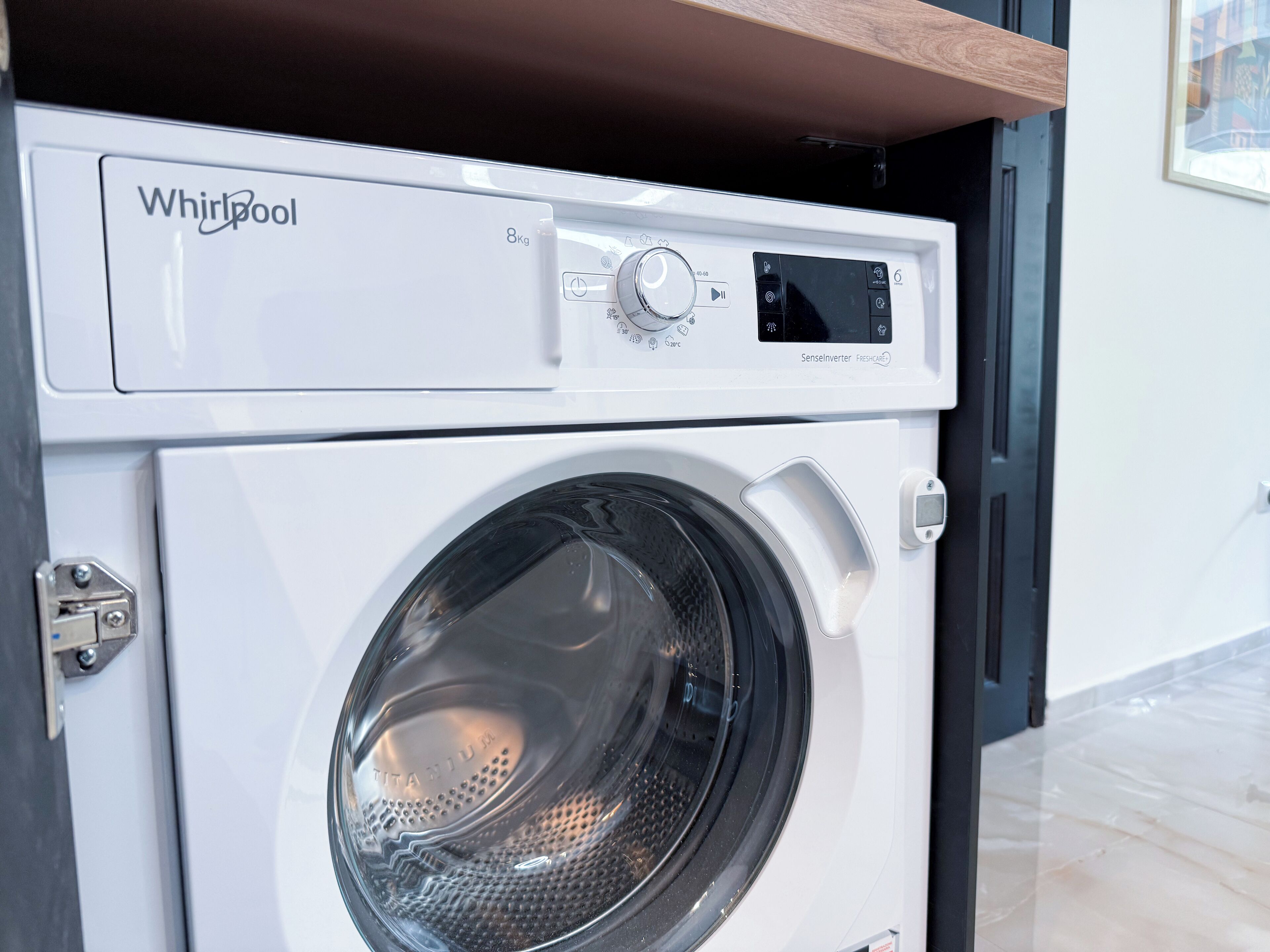 En Whirlpool vaskemaskine med digital kontrolpanel og en ståldør.