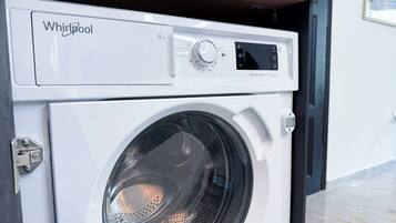 En Whirlpool vaskemaskine med digital kontrolpanel og en ståldør.